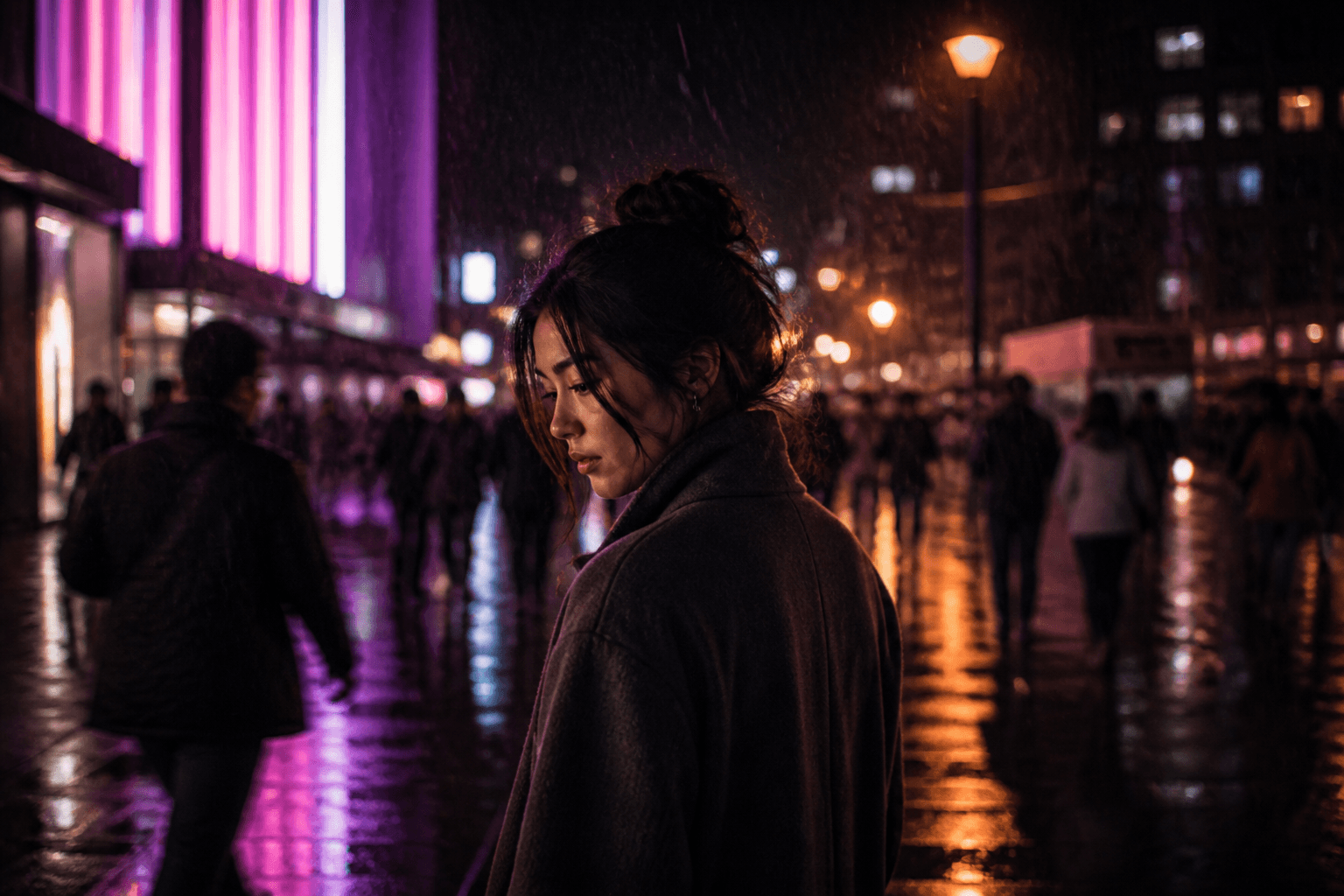 A woman standing still in a rain-wet city at night while the crowd moves past her